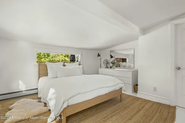 a bedroom with a bed and a painting on the wall