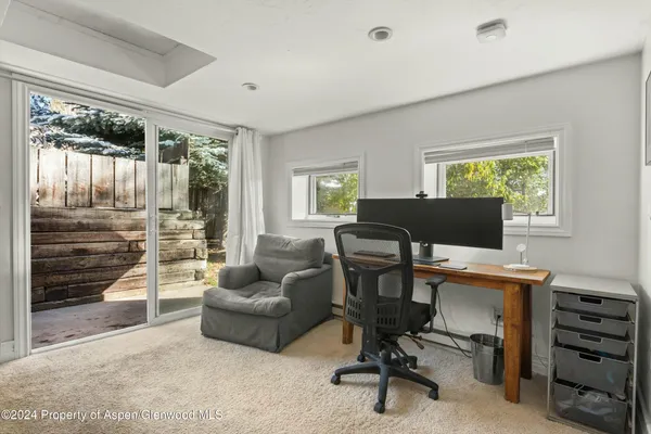 a view of a livingroom with workspace and a window