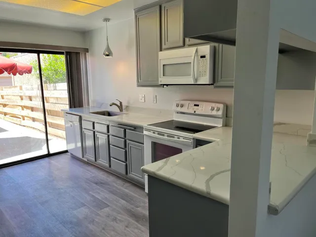 a kitchen with stainless steel appliances granite countertop a stove a sink and a microwave