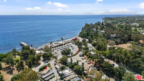 an aerial view of a house with a yard and lake