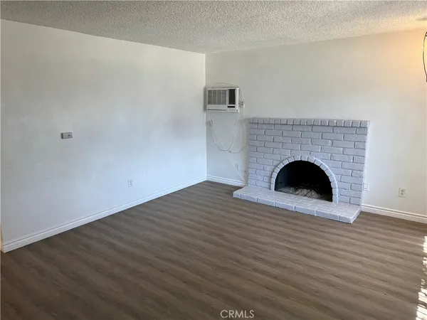 a view of empty room with wooden floor and fireplace