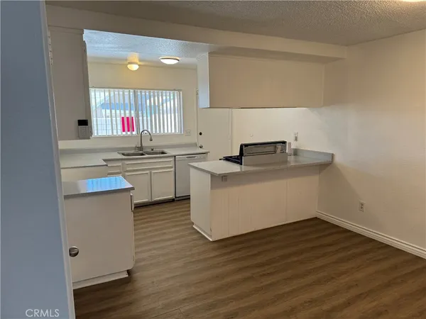 a kitchen with stainless steel appliances granite countertop a sink stove and wooden floor