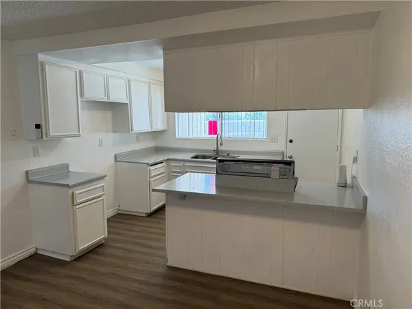a kitchen with a sink cabinets and wooden floor