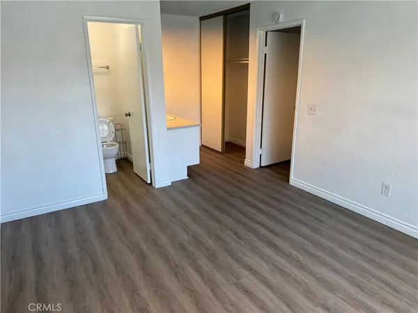 an empty room with wooden floor and entrance