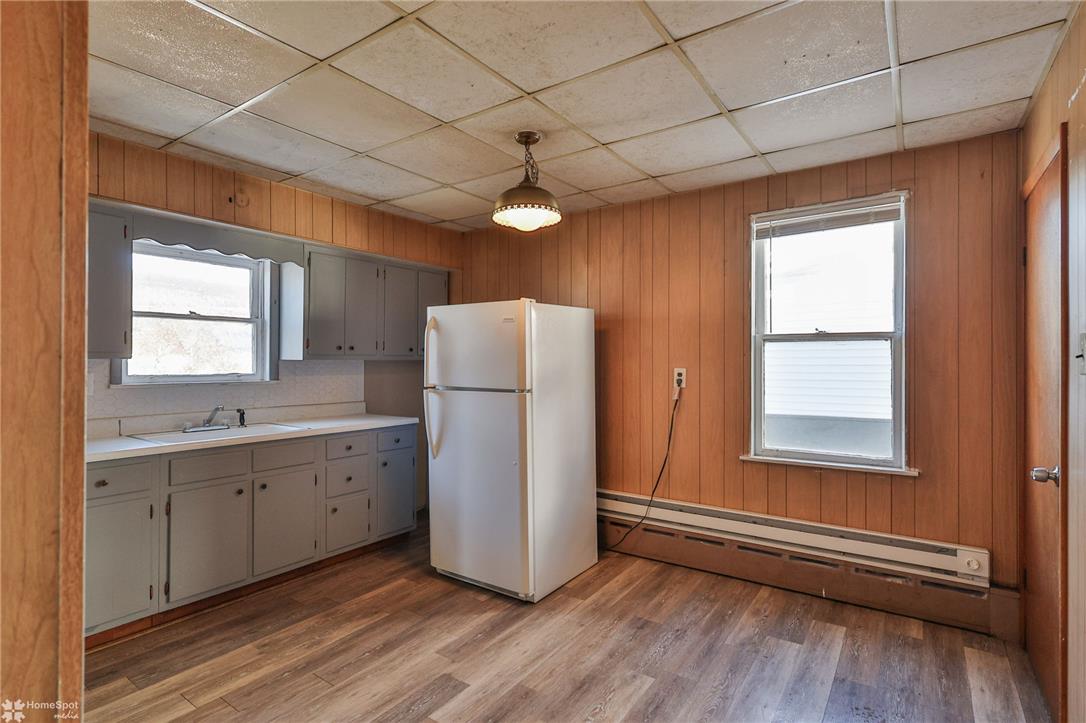 115 East Ruddle Street Coaldale, PA 18218 - Photo 33 of 57 Classic wood paneling and durable vinyl plank flooring define this functional kitchen space.