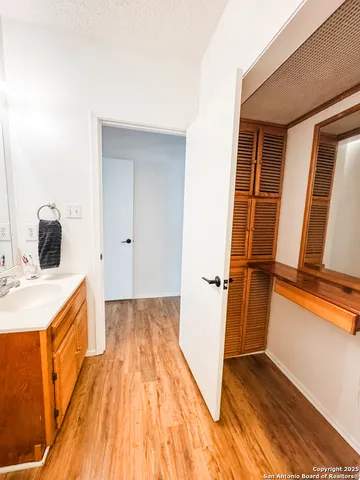 a view of a bedroom with wooden floor and a sink