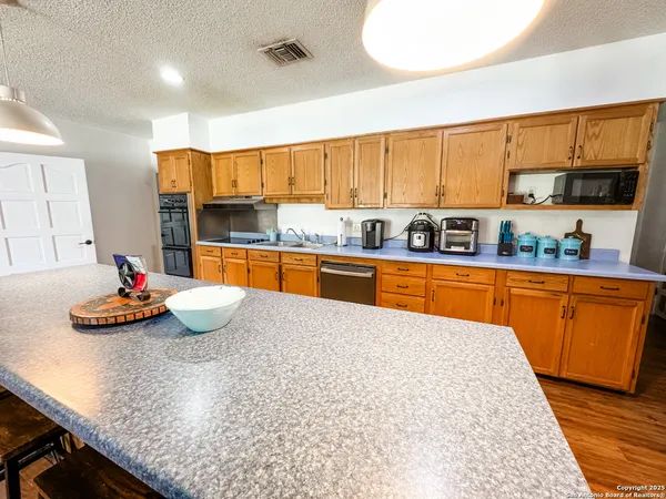 a kitchen with stainless steel appliances granite countertop a sink dishwasher stove and cabinets