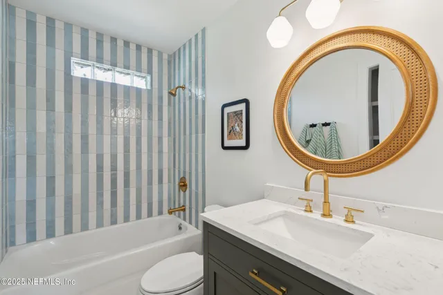 a bathroom with a granite countertop toilet sink and mirror