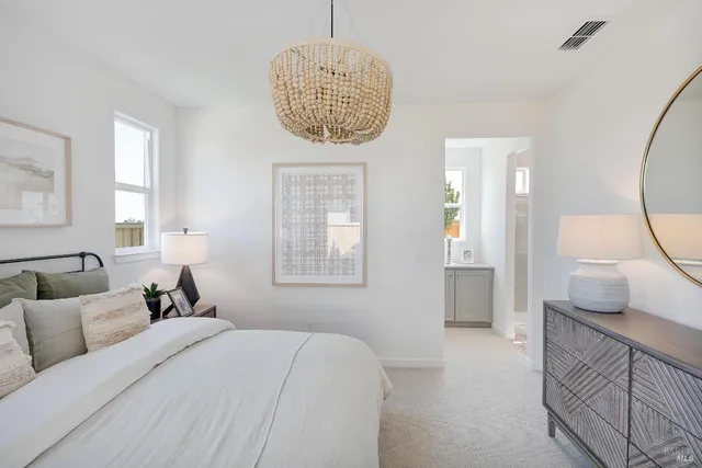 a spacious bedroom with a large bed and a chandelier