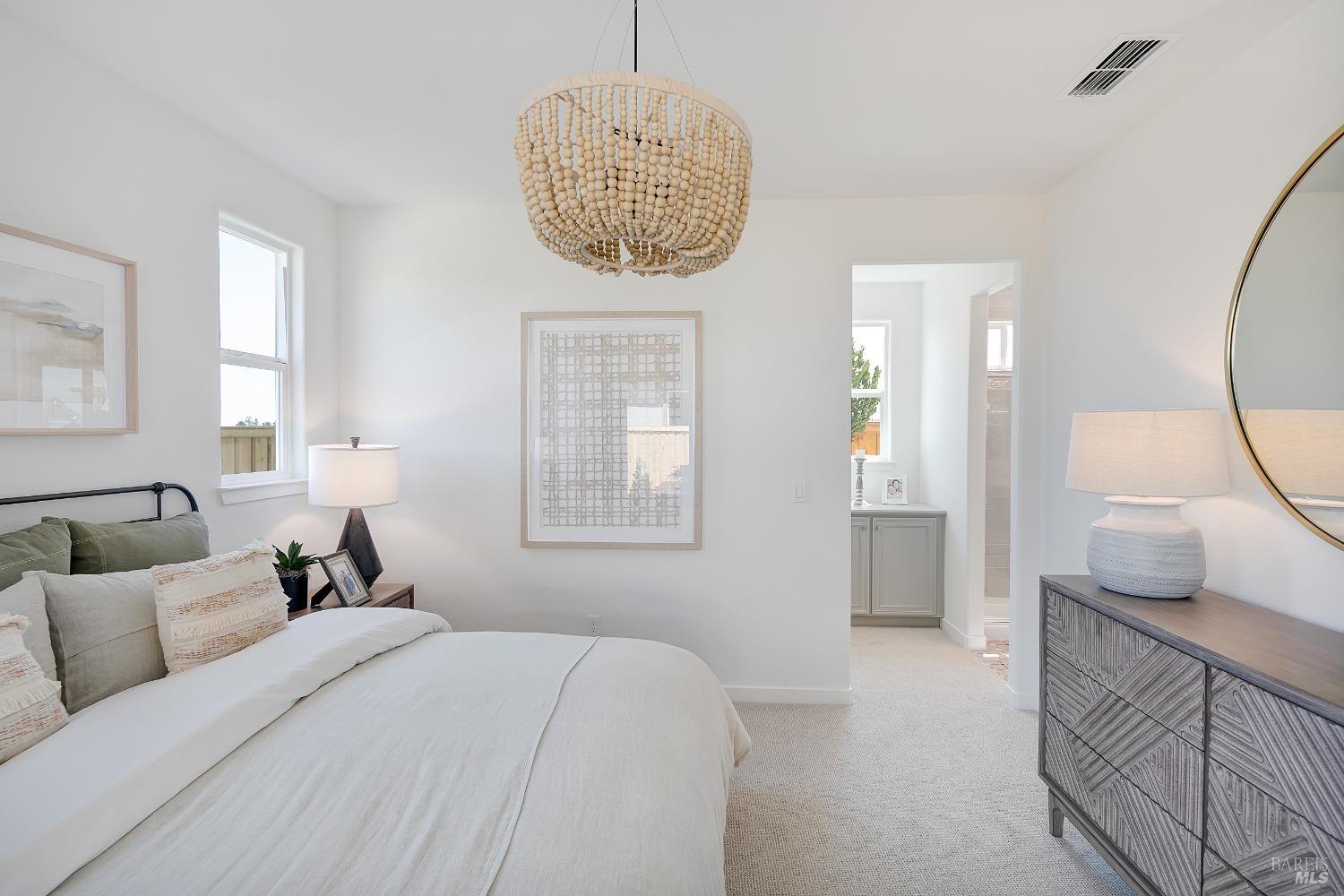 2438 Revival Lane Rio Vista, CA 94571 - Photo 23 of 40 a spacious bedroom with a large bed and a chandelier