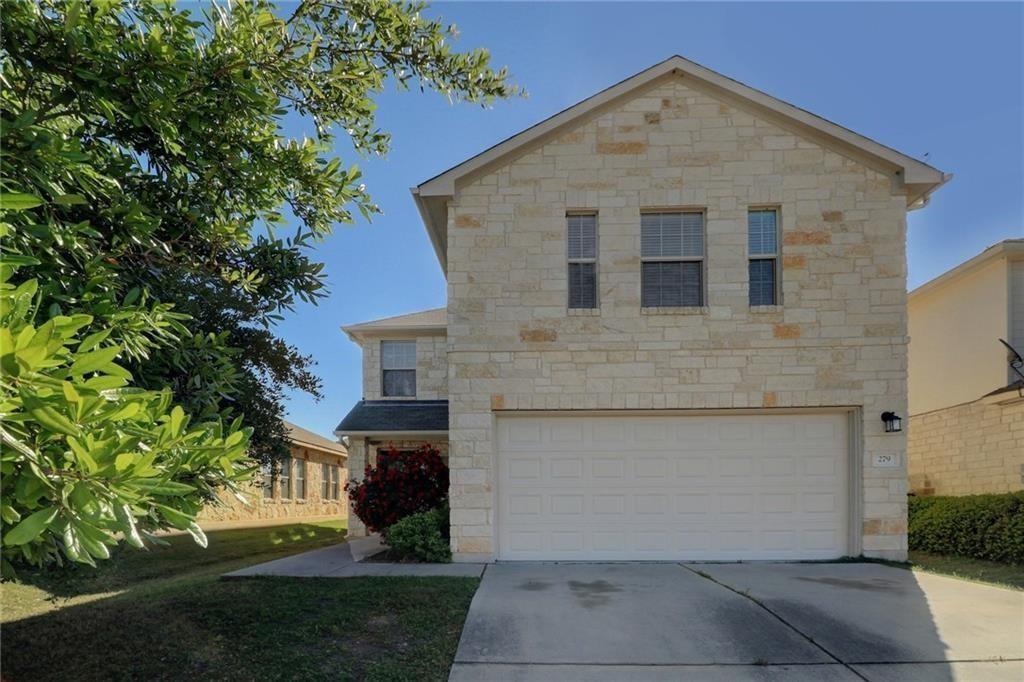 View of front of house featuring stone siding, driveway, and a front yard