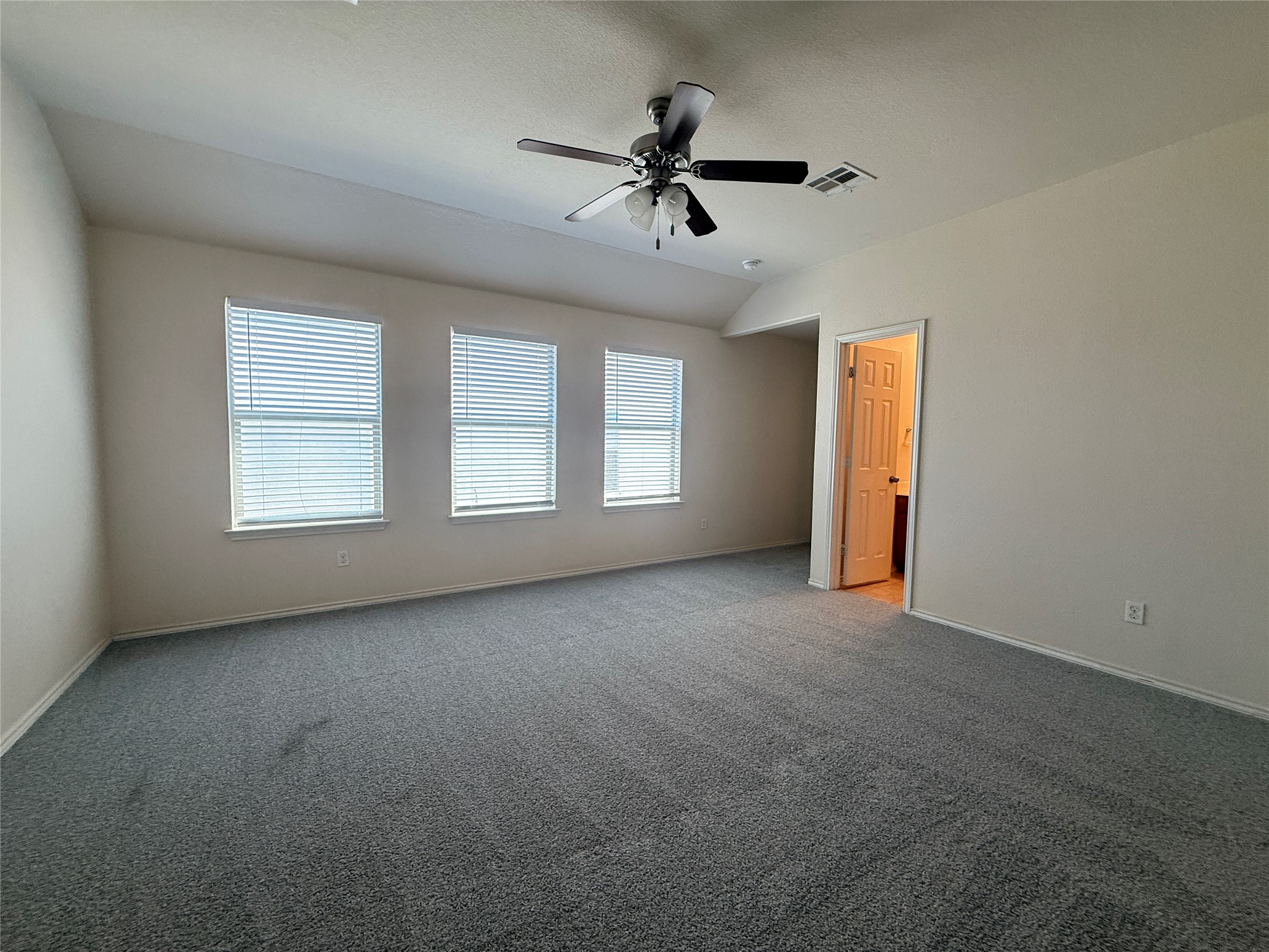 279 Housefinch Loop Leander, TX 78641 - Photo 18 of 30 Carpeted empty room featuring a ceiling fan and lofted ceiling