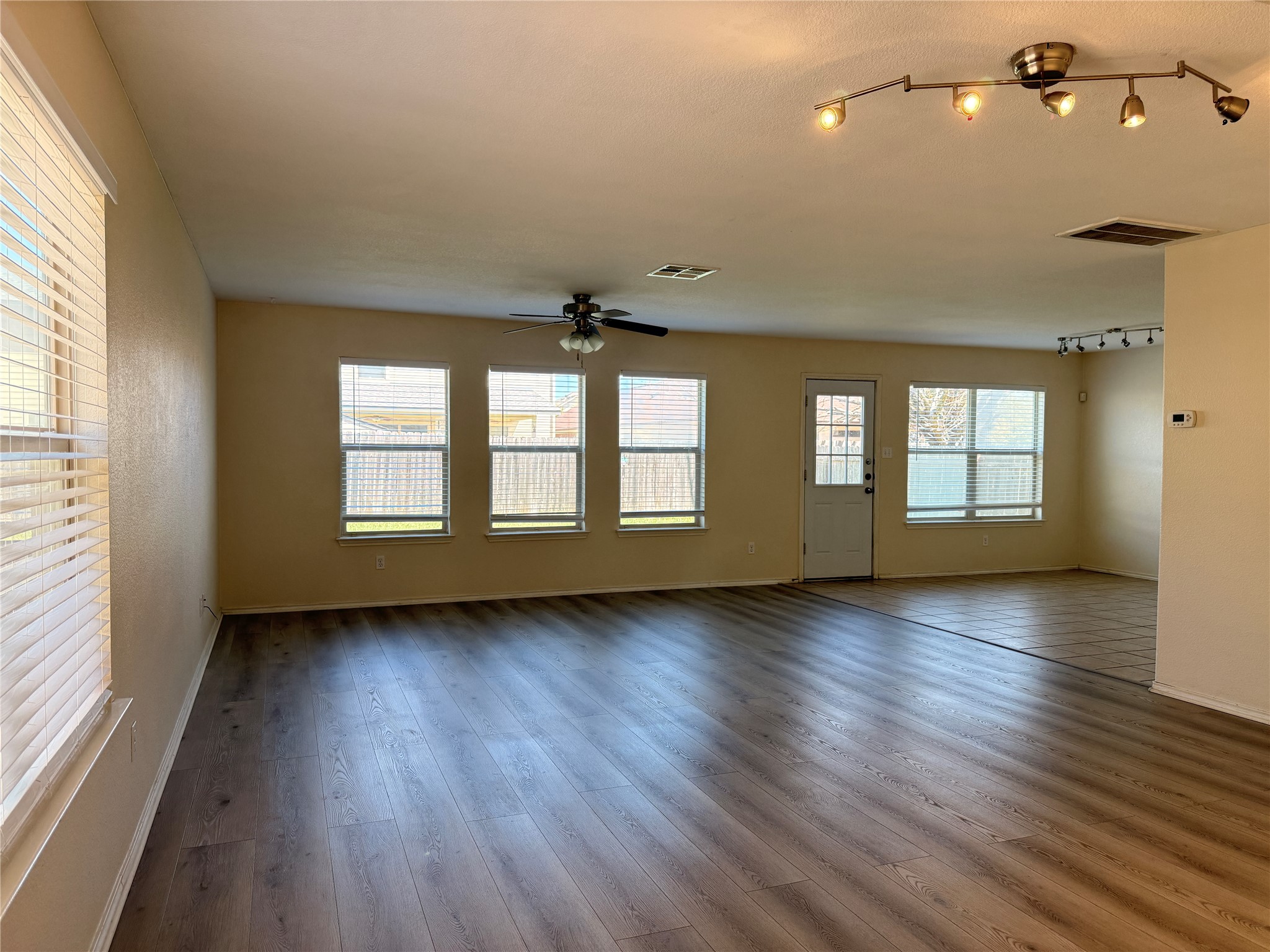 279 Housefinch Loop Leander, TX 78641 - Photo 6 of 30 Unfurnished living room with dark wood-style floors, a ceiling fan, and track lighting