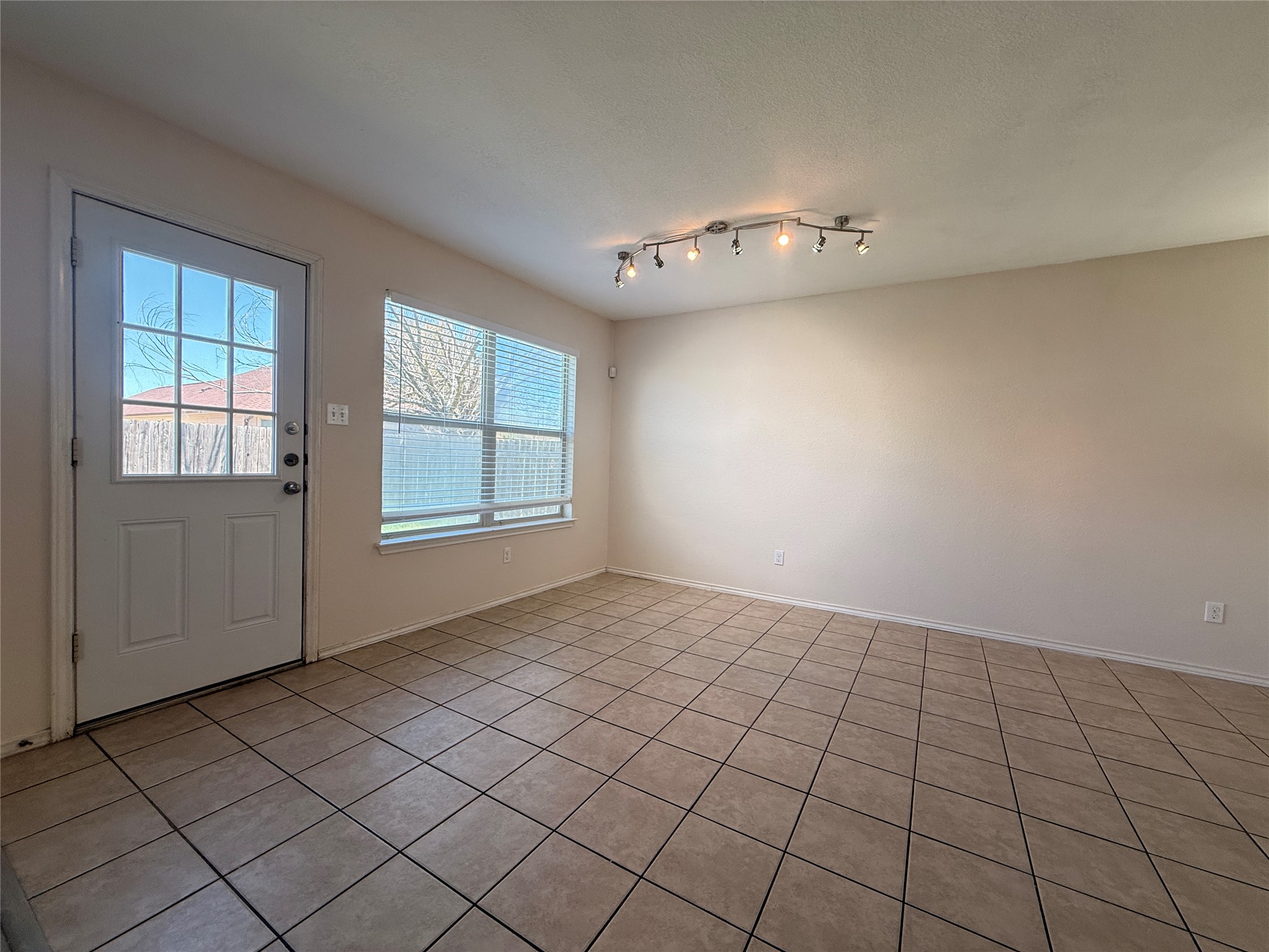 279 Housefinch Loop Leander, TX 78641 - Photo 7 of 30 Unfurnished dining area with light tile patterned floors and a textured ceiling