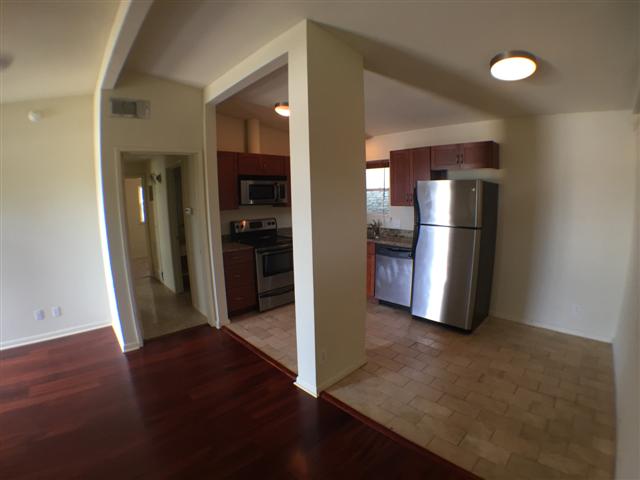 2703 Swisher Street, Unit 203A Austin, TX 78705 - Photo 11 of 11 an empty room with wooden floor and way to kitchen