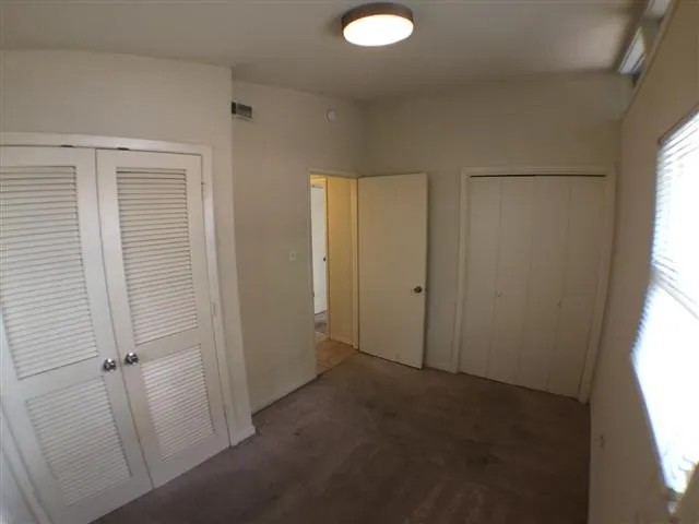 an empty room with windows and closet