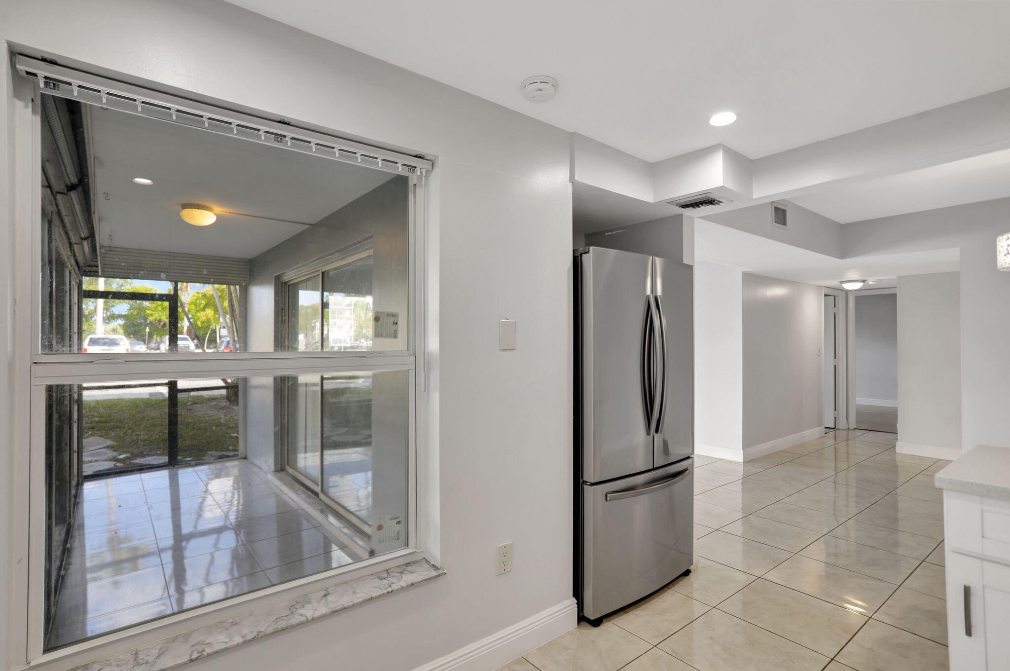 4156 Inverrary Drive, Unit 111 Lauderhill, FL 33319 - Photo 13 of 18 a kitchen with a refrigerator and countertop