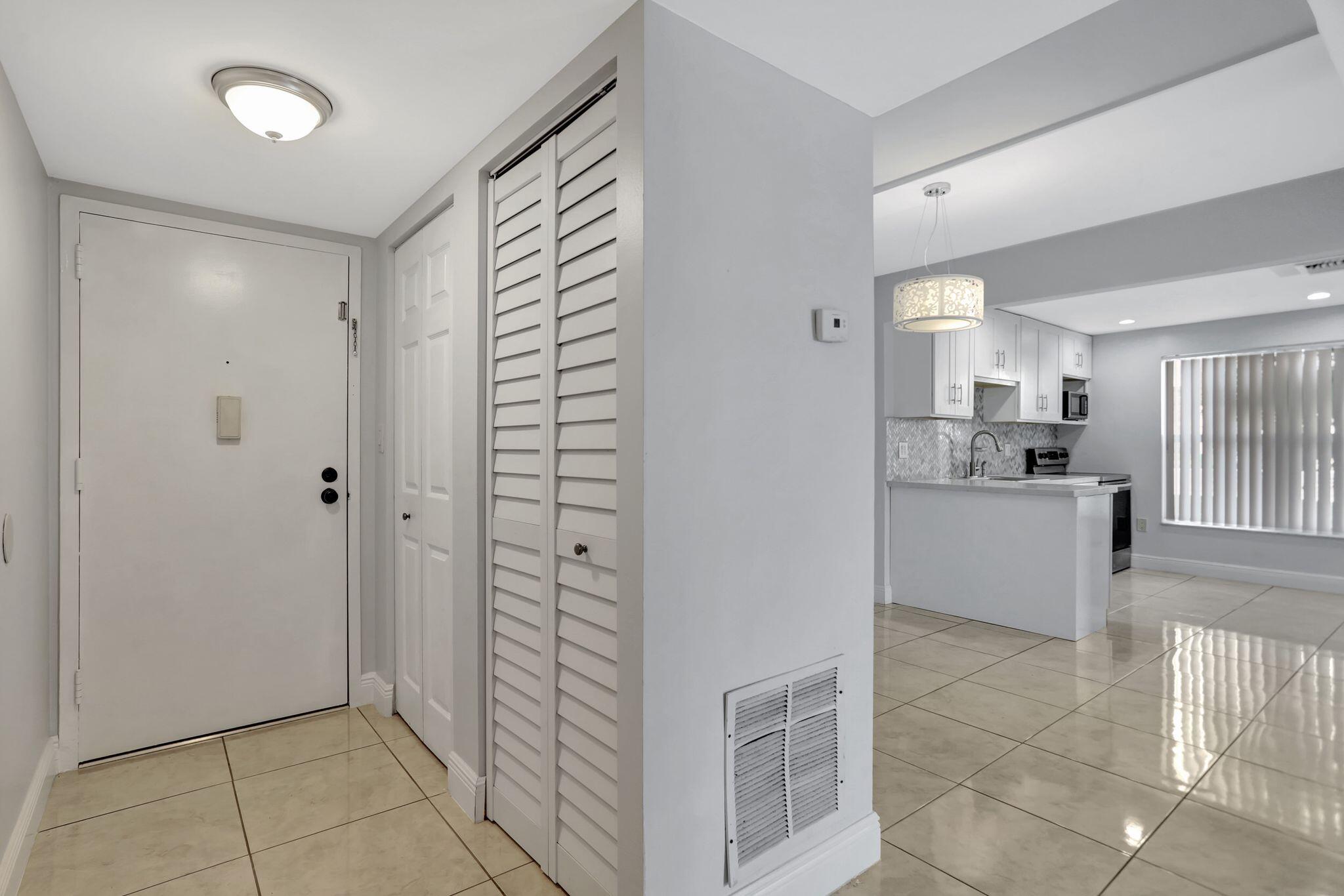 4156 Inverrary Drive, Unit 111 Lauderhill, FL 33319 - Photo 4 of 18 a view of kitchen with refrigerator and white cabinets