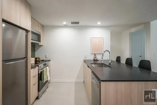 a kitchen with stainless steel appliances granite countertop a sink a refrigerator and a stove