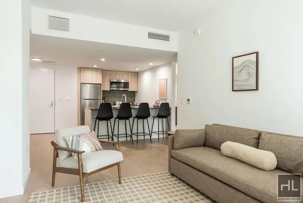 a living room with furniture and a dining table with kitchen view