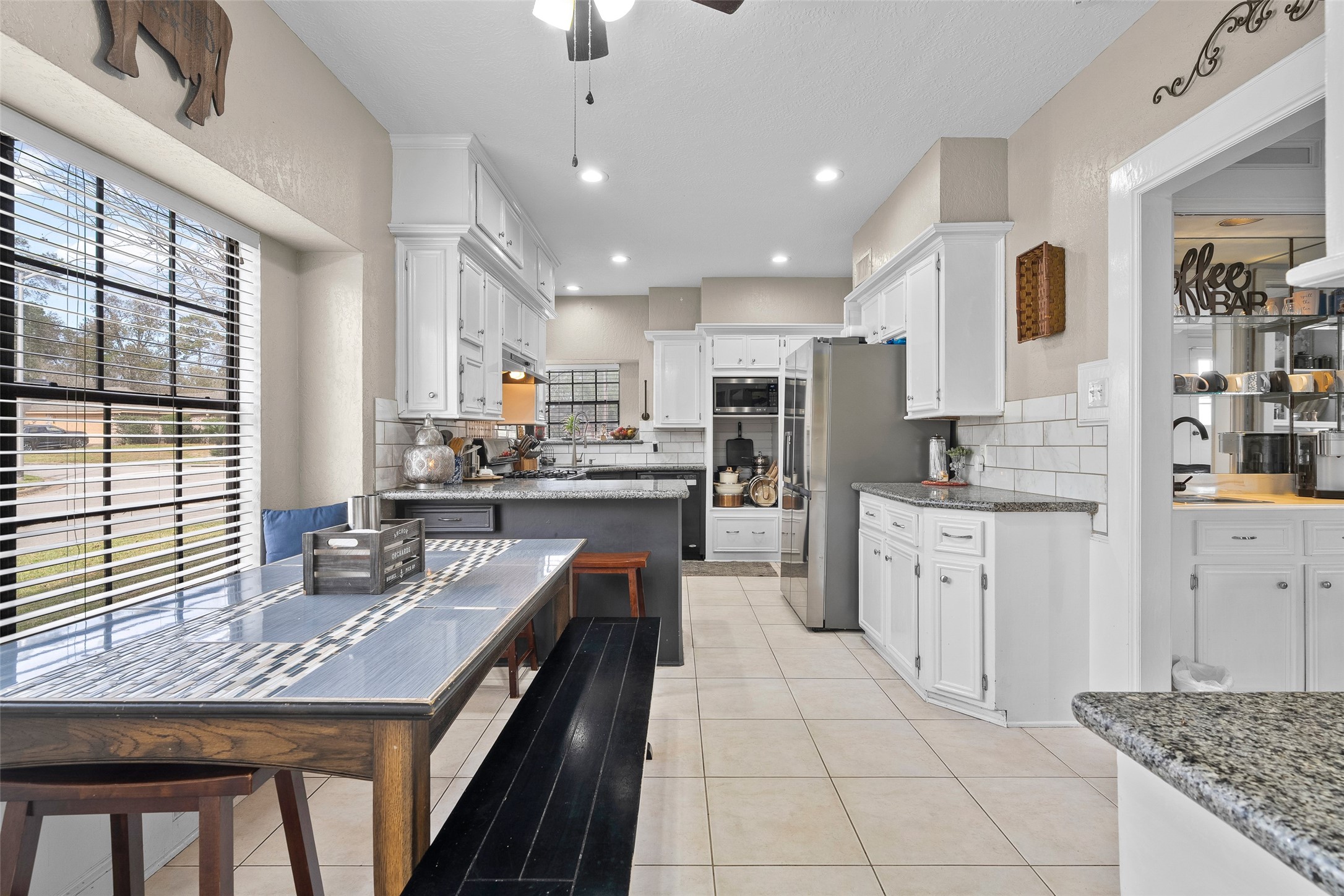 41 Windsor Drive Conroe, TX 77304 - Photo 14 of 39 This view shows the kitchen layout with ample cabinet storage, granite countertops, and recessed lighting. The space connects directly to the breakfast area for everyday functionality.