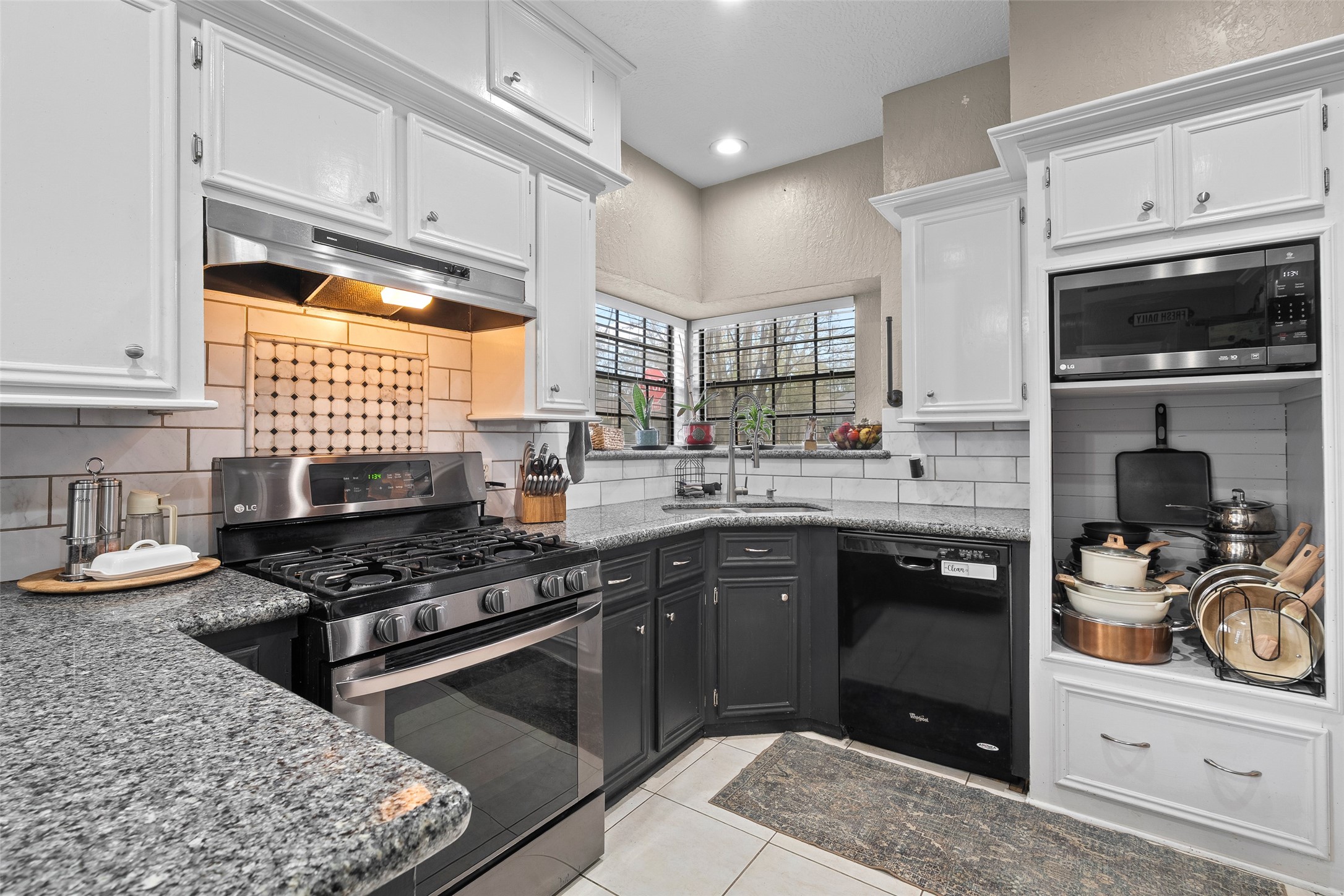 41 Windsor Drive Conroe, TX 77304 - Photo 19 of 39 Close-up view of the kitchen shows granite countertops, gas range, and tile backsplash, emphasizing functional finishes.