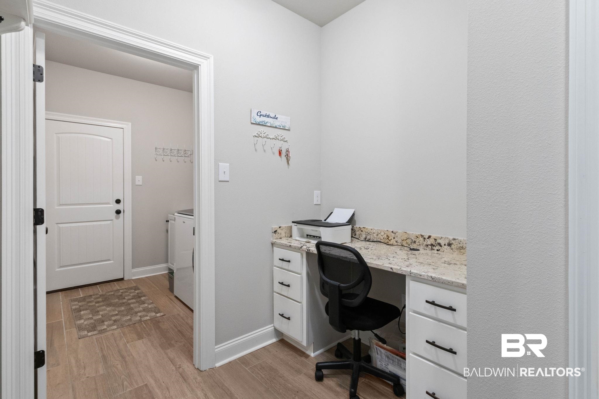 22244 Hibiscus Circle Foley, AL 36535 - Photo 34 of 51 Integrated desk area featuring white cabinetry with black hardware and a speckled stone countertop