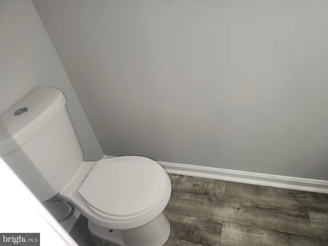a white toilet sitting next to a shower