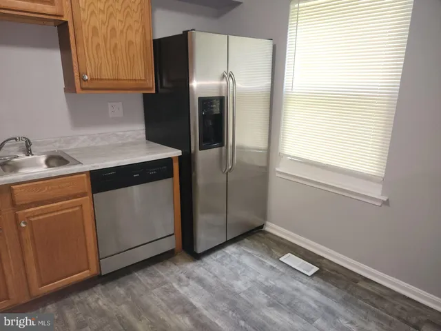 a kitchen with a refrigerator sink and cabinets