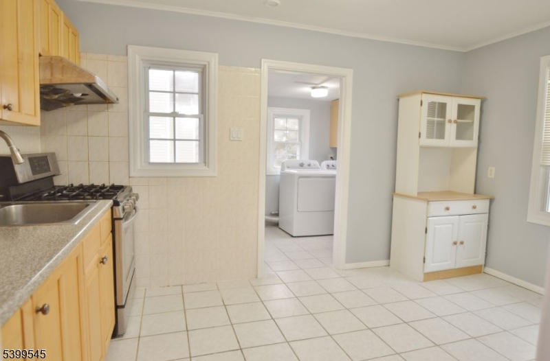 11 Bogota Road Parsippany, NJ 07054 - Photo 3 of 12 a kitchen with white cabinets a sink a stove and a window