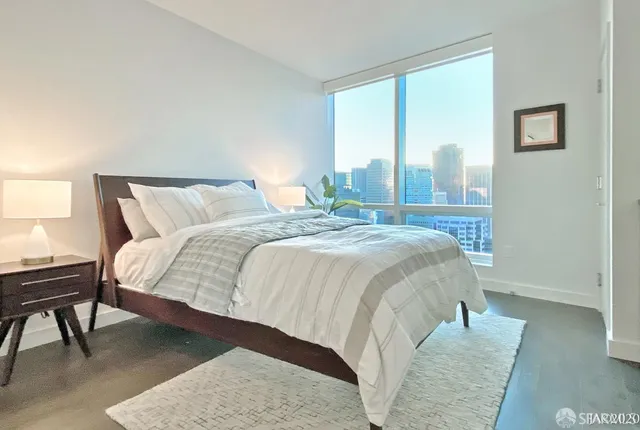 a bed sitting in a bedroom next to a window