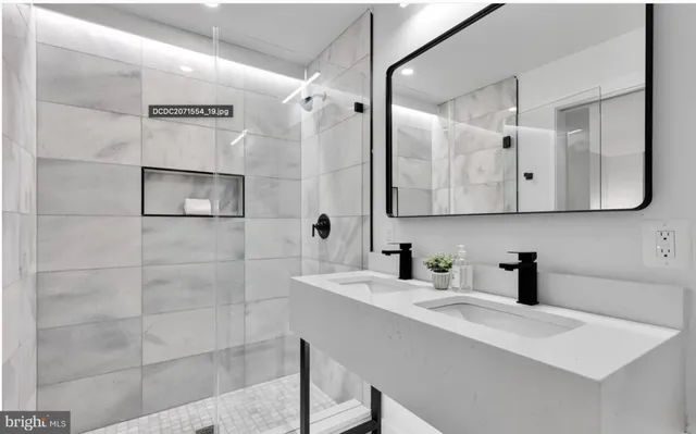 a bathroom with a sink a mirror a vanity and shower