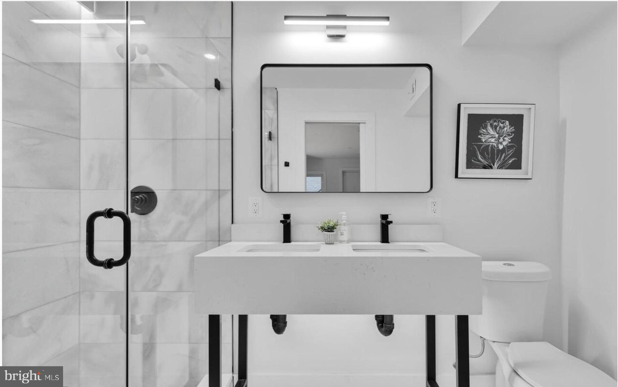 718 6th Street Northeast, Unit 1 Washington, DC 20002 - Photo 15 of 21 a bathroom with a double vanity sink a toilet and a mirror