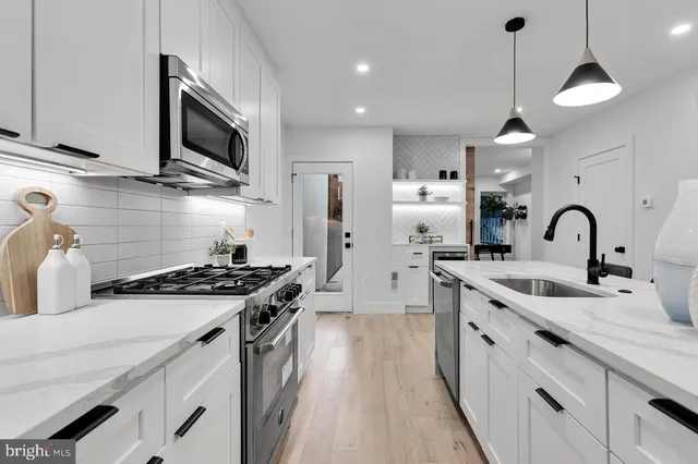 a kitchen with stainless steel appliances a sink stove and refrigerator