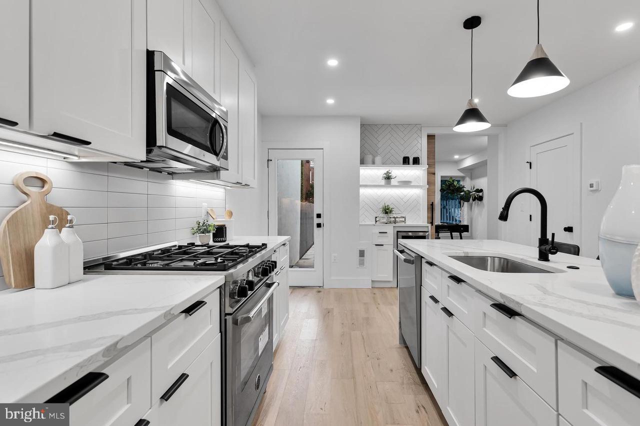 718 6th Street Northeast, Unit 1 Washington, DC 20002 - Photo 5 of 21 a kitchen with stainless steel appliances a sink stove and refrigerator