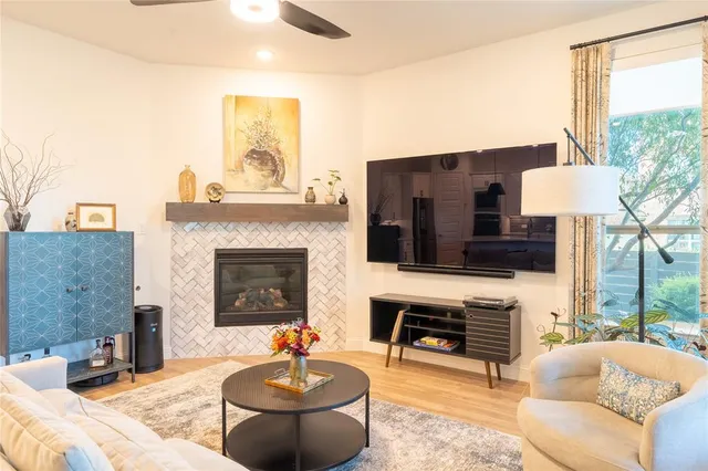 a living room with furniture a fireplace and a large window