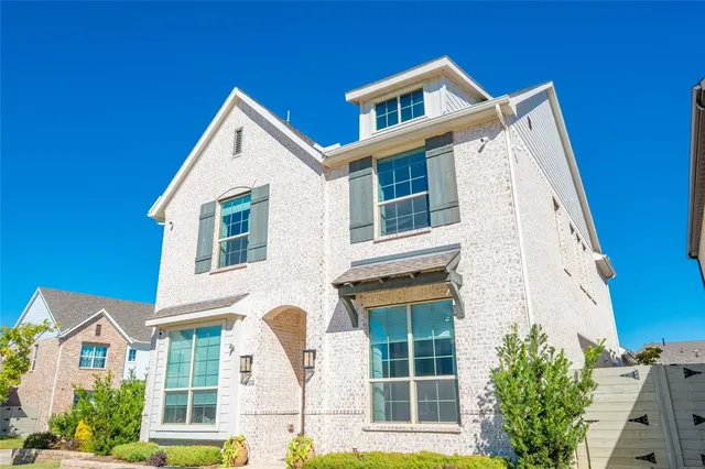 a view of a house with a yard and potted plants