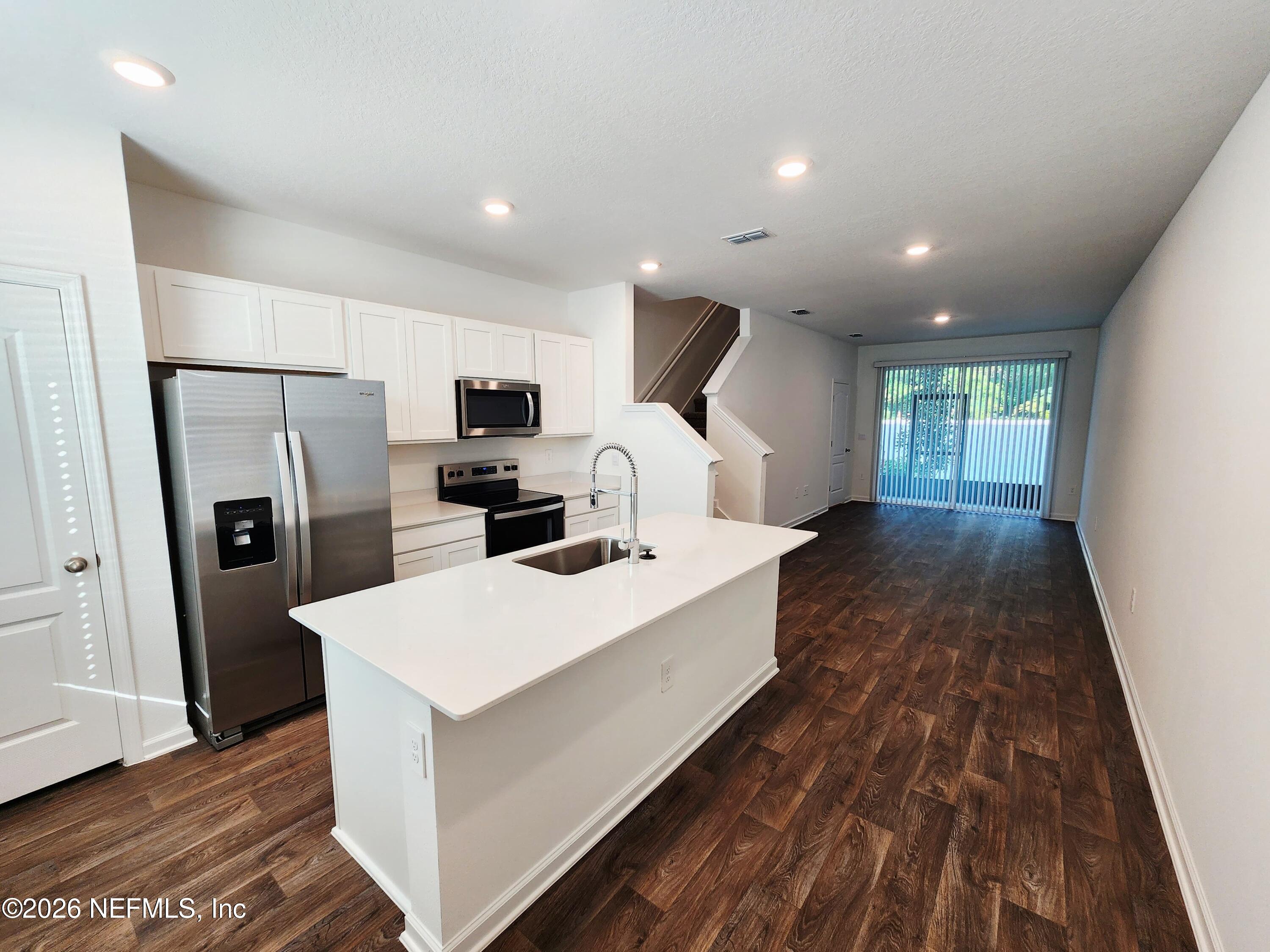 51 Palmetto Rdg Road St. Augustine, FL 32095 - Photo 2 of 16 a large white kitchen with sink a refrigerator and a stove