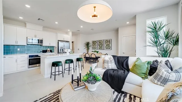 a living room with furniture kitchen and a potted plant
