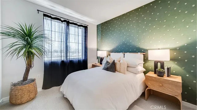 a bedroom with a large bed and a potted plant