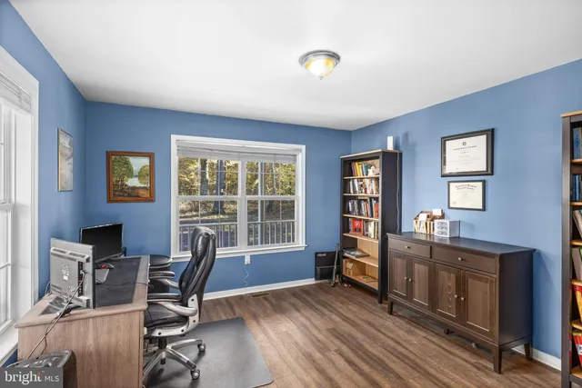 a living room with furniture a fireplace a flat screen tv and kitchen view