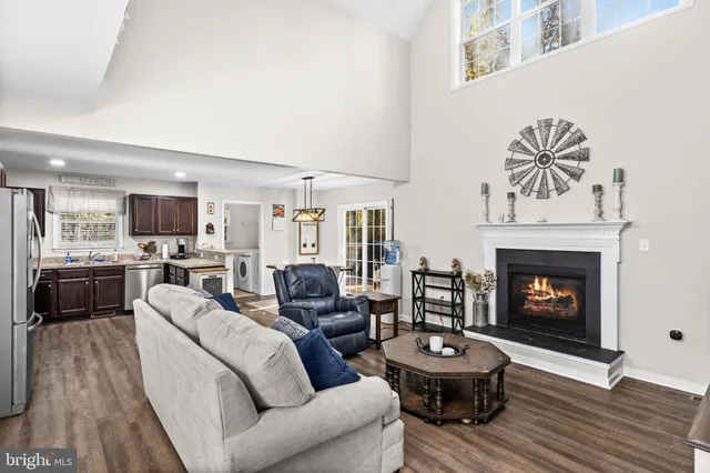 a living room with furniture a flat screen tv and kitchen view