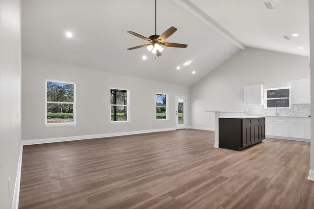 a view of a livingroom with a ceiling fan and wooden floor