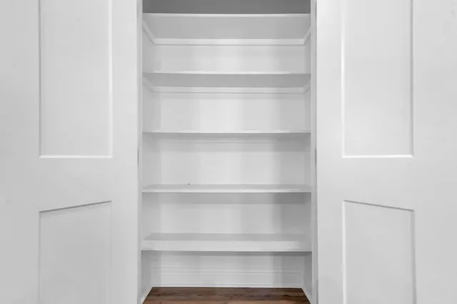 a view of walk in closet with empty racks