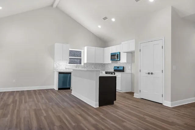 a kitchen with granite countertop a refrigerator and a stove top oven
