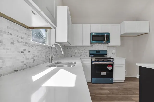 a kitchen with stainless steel appliances a stove a sink and a microwave