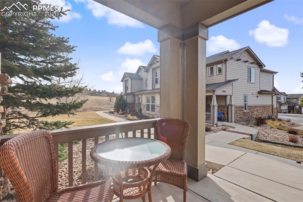 17063 Blue Mist Grove Monument, CO 80132 - Photo 2 of 33 a view of a balcony with a table and chairs and wooden floor