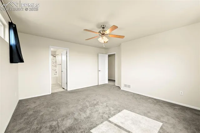 a view of a big room with carpet and fan