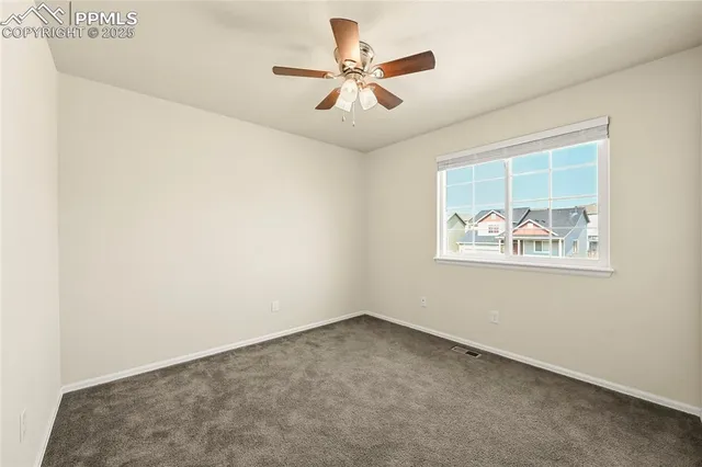 an empty room with a window and a ceiling fan