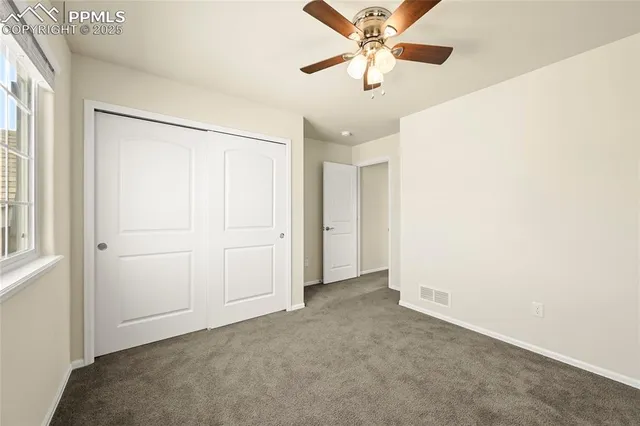 an empty room with a ceiling fan and a window